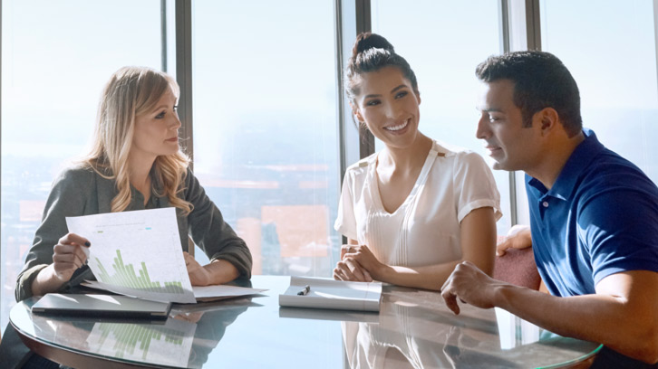Individuals reviewing an investment portfolio